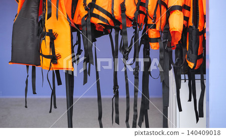 Orange life jackets hanging displaying safety equipment 140409018
