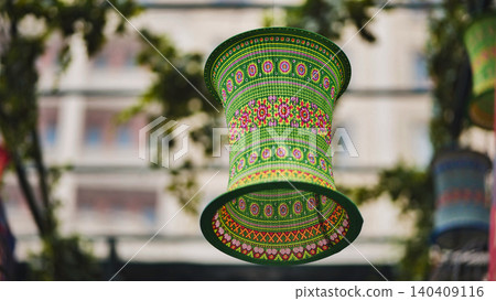 Colorful traditional green lantern with intricate patterns hanging outdoors Colorful traditional green lantern with intricate patterns hanging outdoors 140409116