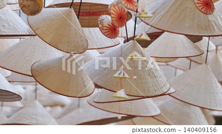 Traditional Vietnamese conical hats, Non La, hanging as a cultural background display. Asian handmade craft. Traditional Vietnamese conical hats, Non La, hanging as a cultural background display. Asian handmade craft. 140409156