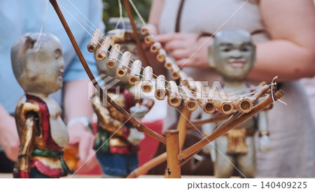 Traditional handmade bamboo instrument and carved puppets at an outdoor market. Traditional handmade bamboo instrument and carved puppets at an outdoor market. 140409225