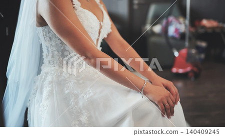 Bride in elegant white lace wedding dress sits calmly before the ceremony. Bride in elegant white lace wedding dress sits calmly before the ceremony. 140409245