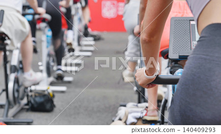 Athletes pedaling on exercise bikes during sports day Athletes pedaling on exercise bikes during sports day 140409293
