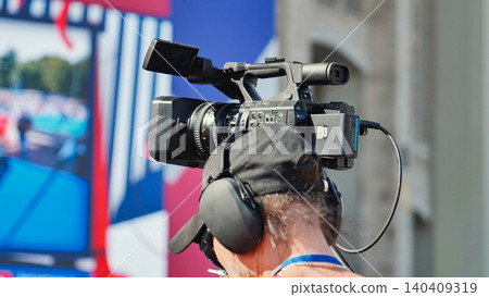 Videographer recording sport event with professional camcorder 140409319