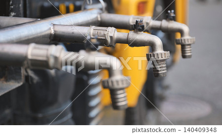 Multiple metal taps delivering water from system on a yellow utility truck Multiple metal taps delivering water from system on a yellow utility truck 140409348