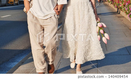 walking on sidewalk holding hands with tulips on a sunny day walking on sidewalk holding hands with tulips on a sunny day 140409454