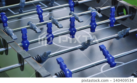 Foosball table players on game field displaying competitive recreation activity 140409534