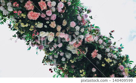 Cascading floral arrangement forming a colorful arch against white background 140409599