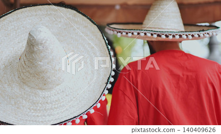 People wearing traditional sombreros celebrating Mexican culture at a festive event People wearing traditional sombreros celebrating Mexican culture at a festive event 140409626
