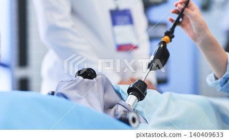 Surgeon performing laparoscopic surgery using medical technology in a modern hospital Surgeon performing laparoscopic surgery using medical technology in a modern hospital 140409633