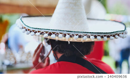 Musician with sombrero using phone during mexican festival 140409636