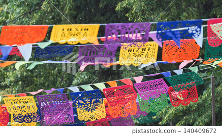Papel picado and colorful bunting flags decorating for a festive Mexican celebration Papel picado and colorful bunting flags decorating for a festive Mexican celebration 140409672
