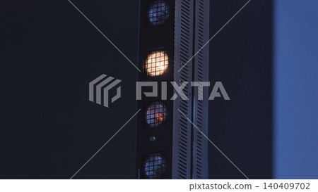 Professional stage light bar featuring multiple glowing bulbs on a deep blue background Professional stage light bar featuring multiple glowing bulbs on a deep blue background 140409702