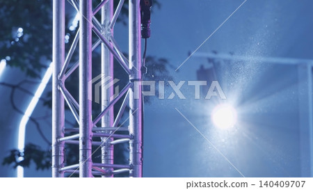 Stage lighting equipment with glowing truss structure at an outdoor event Stage lighting equipment with glowing truss structure at an outdoor event 140409707