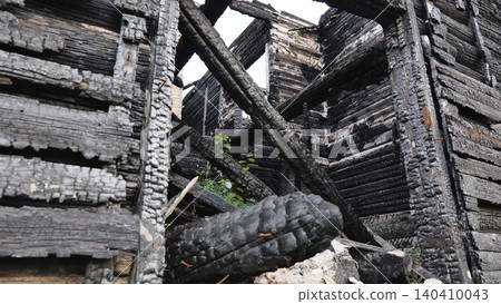 Charred wooden logs from a destroyed house after a devastating fire disaster Charred wooden logs from a destroyed house after a devastating fire disaster 140410043