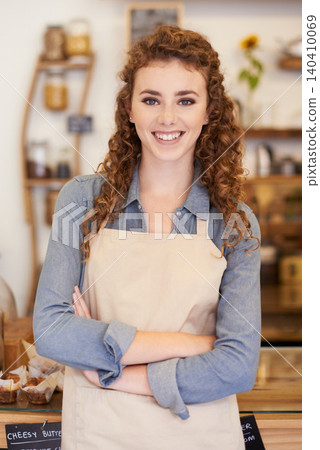 Portrait, welcome and woman with confidence in bakery for service with happy small business owner. Coffee shop, restaurant or girl manager with smile, hospitality or entrepreneur at startup cafe. Portrait, welcome and woman with confidence in bakery for service with happy small business owner. Coffee shop, restaurant or girl manager with smile, hospitality or entrepreneur at startup cafe. 140410069