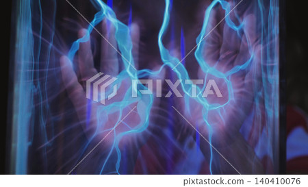 Hand interacting with glowing plasma energy in a science experiment Hand interacting with glowing plasma energy in a science experiment 140410076