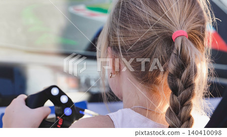 Young girl playing racing video game simulation with steering wheel controller Young girl playing racing video game simulation with steering wheel controller 140410098