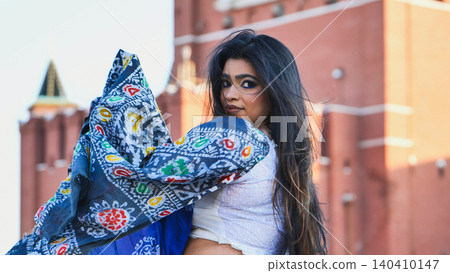 Bangladeshi woman posing in Moscow with a colorful scarf and blurred Kremlin background 140410147