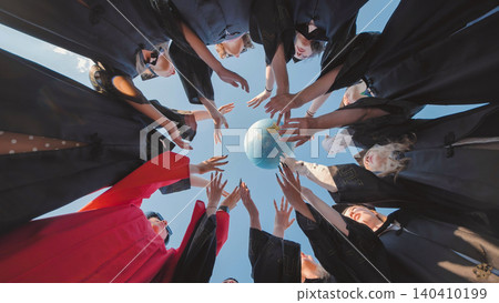 Graduates in cap and gown reaching for a globe, symbolizing global prospects and cross border cooperation post graduation Graduates in cap and gown reaching for a globe, symbolizing global prospects and cross border cooperation post graduation 140410199