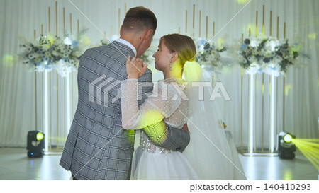 Romantic newlyweds slow dancing, embracing intimately during wedding reception, soft lighting highlighting tender moment of marital bliss Romantic newlyweds slow dancing, embracing intimately during wedding reception, soft lighting highlighting tender moment of marital bliss 140410293