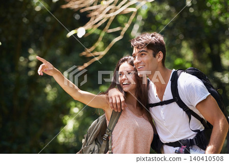 Couple, point and smile for hiking in jungle with sign for thinking, holiday and happy on path. Man, woman and bag for trekking, direction and search in rainforest with ideas at location in Colombia Couple, point and smile for hiking in jungle with sign for thinking, holiday and happy on path. Man, woman and bag for trekking, direction and search in rainforest with ideas at location in Colombia 140410508