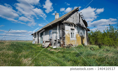 Old abandoned wooden house falling apart in slavic village under blue sky 140410517