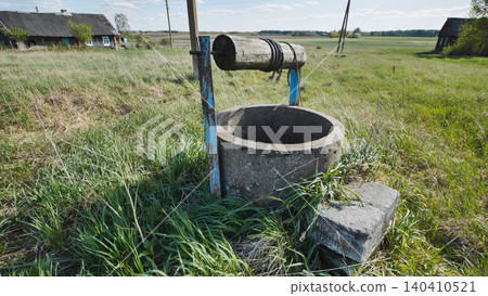 Old abandoned well with wooden roller and rope in slavic village Old abandoned well with wooden roller and rope in slavic village 140410521
