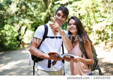 Couple, map and point for hiking in forest with reading for thinking, holiday and ideas on path. Man, woman and bag for trekking, direction and search in jungle with book for location in Colombia Couple, map and point for hiking in forest with reading for thinking, holiday and ideas on path. Man, woman and bag for trekking, direction and search in jungle with book for location in Colombia 140410740
