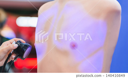 Innovative medical technology demonstration using UV light on mannequin chest at forum 140410849