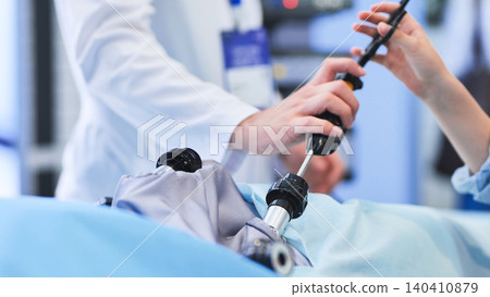 Medical team performing minimally invasive surgery using advanced surgical equipment in a hospital Medical team performing minimally invasive surgery using advanced surgical equipment in a hospital 140410879