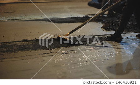 Road construction workers paving fresh asphalt at night, improving city infrastructure Road construction workers paving fresh asphalt at night, improving city infrastructure 140410921