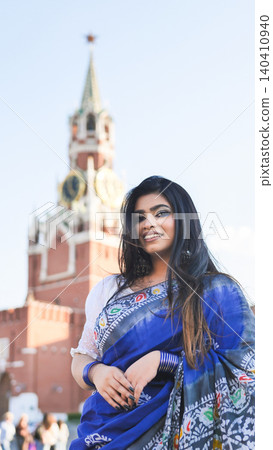 Woman wearing blue sari smiling, traveling in Russia, showcasing cultural diversity 140410940
