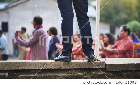 Person observing a Hindu Ganesh Chaturthi community celebration with people dancing Person observing a Hindu Ganesh Chaturthi community celebration with people dancing 140411098