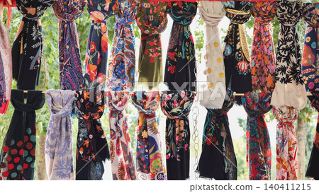 Colorful patterned scarves hanging on display in India 140411215