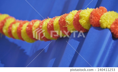 Red and yellow garland hanging on blue background representing India Red and yellow garland hanging on blue background representing India 140411253