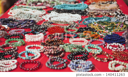 Colorful bracelets and necklaces resting on red cloth in India 140411263