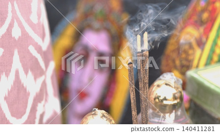 Incense sticks burning with smoke in front of Indian Goddess Durga Incense sticks burning with smoke in front of Indian Goddess Durga 140411281