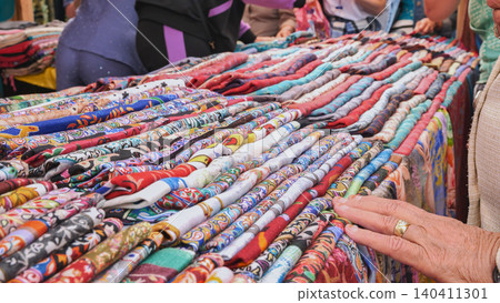 Vendor showing colorful pashminas at indian market Vendor showing colorful pashminas at indian market 140411301