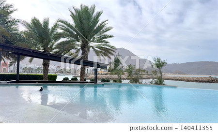 Resort infinity pool with palm trees and mountain view Resort infinity pool with palm trees and mountain view 140411355