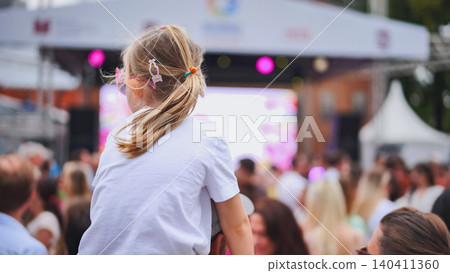 Little girl enjoying latin american festival with crowd watching live music concert Little girl enjoying latin american festival with crowd watching live music concert 140411360