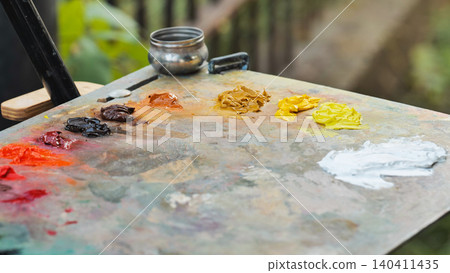 Oil paint tubes laying on an artist's palette creating a colorful composition Oil paint tubes laying on an artist's palette creating a colorful composition 140411435