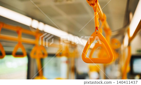 Close-up of an orange handle inside a public transport vehicle, offering stability for commuters Close-up of an orange handle inside a public transport vehicle, offering stability for commuters 140411437