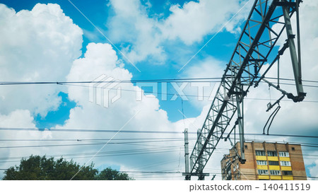 Moscow railway catenary infrastructure against a bright blue sky with clouds 140411519