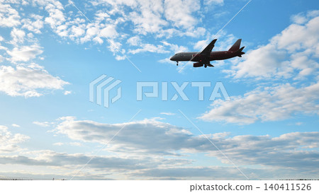 Airplane descending against blue sky, preparing to land at airport Airplane descending against blue sky, preparing to land at airport 140411526