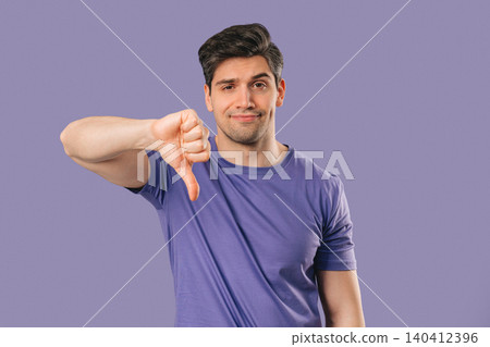 Portrait of unhappy man condemns with sign of dislike. Young millennial guy Portrait of unhappy man condemns with sign of dislike. Young millennial guy 140412396