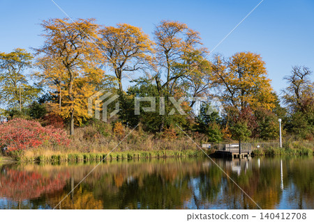 City park with water reflection lake. Autumn landscape nature. Park pond. Park in autumn with colorful fall trees. Autumn nature. Fall nature landscape. Lake in park with autumn tree 140412708