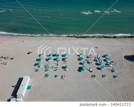 Summer vacation. Beach vacation at sea in summer. Sea relax under beach umbrella. Travel to sea. Luxury resort. Aerial top view of sand beach with sunbed and umbrella Summer vacation. Beach vacation at sea in summer. Sea relax under beach umbrella. Travel to sea. Luxury resort. Aerial top view of sand beach with sunbed and umbrella 140412715