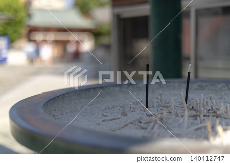 Incense sticks standing in an incense burner and scenes of worshippers at temples and shrines. Incense sticks standing in an incense burner and scenes of worshippers at temples and shrines. 140412747
