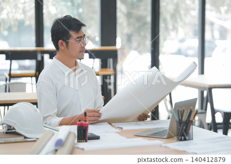 Engineer and Architect Reviewing Interior Design Plans with Laptop and Tools Engineer and Architect Reviewing Interior Design Plans with Laptop and Tools 140412879