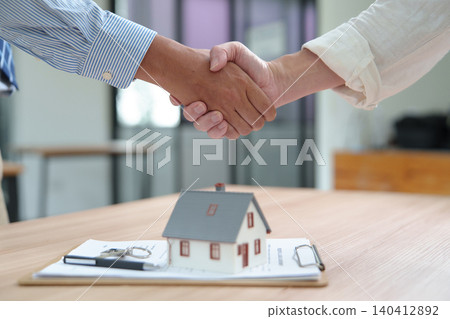 Business Handshake Over Home Purchase Agreement in Real Estate Transaction Business Handshake Over Home Purchase Agreement in Real Estate Transaction 140412892